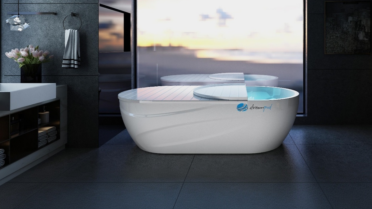 Dreampod Mineral Soaker heated mineral bath system with lid partially open in modern luxury bathroom with large window view