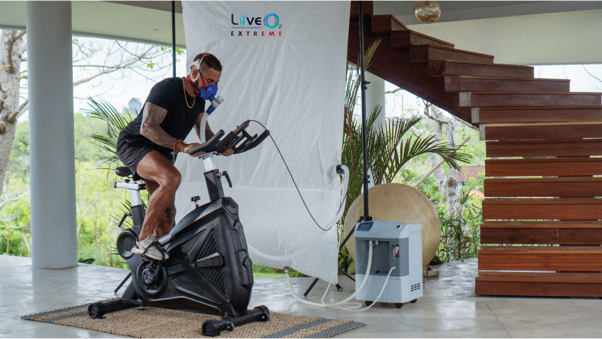 LiveO2 Extreme adaptive contrast EWOT system with man training on exercise bike in home wellness setting