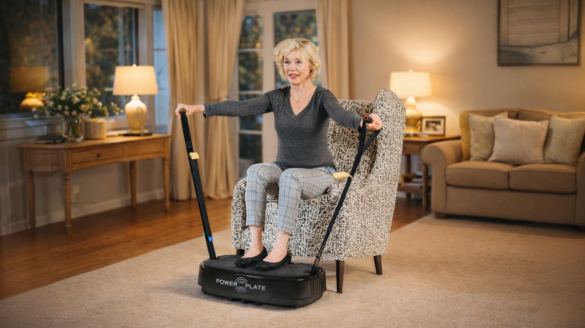 Elderly woman seated using resistance bands on Personal Power Plate vibration platform demonstrating whole body vibration training for strength, mobility, and balance support.