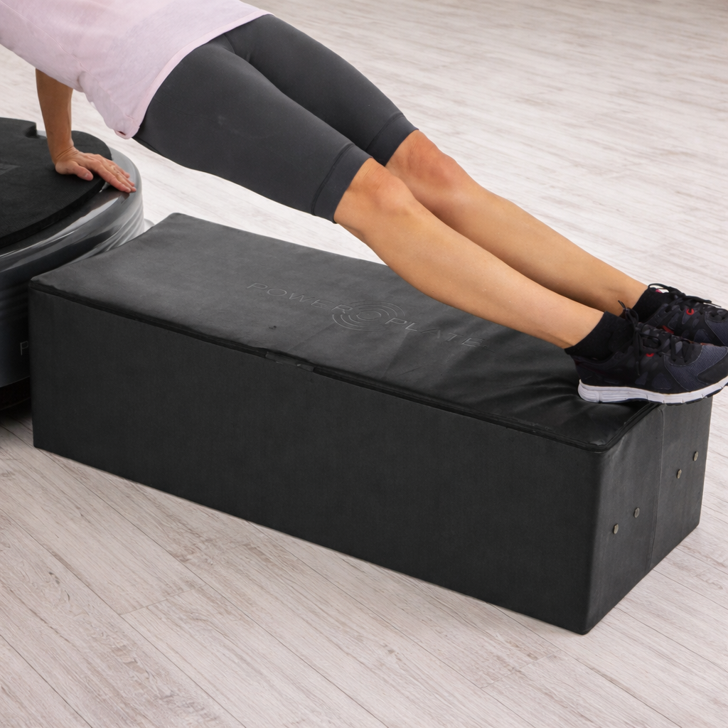 Power Plate Large Support Cushion vibration training accessory supporting feet during triceps exercise on Power Plate vibration platform