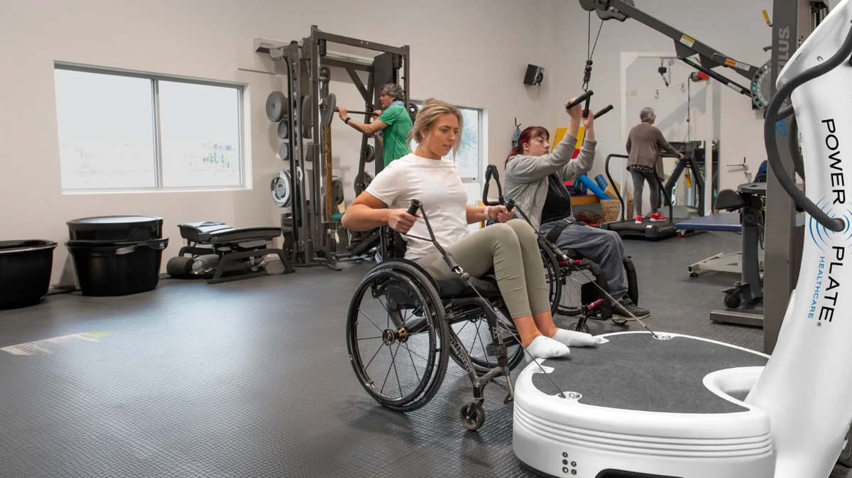 Power Plate pro7HC healthcare vibration platform wheelchair patients performing rehabilitation strength training in medical therapy gym