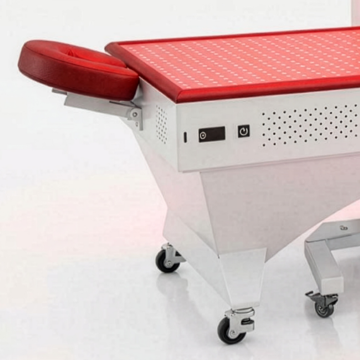 Prestige Pro Modular Red Light Therapy Bed shown in close-up with red adjustable headrest, side control buttons, wheeled base, and lower red light therapy panel detail.
