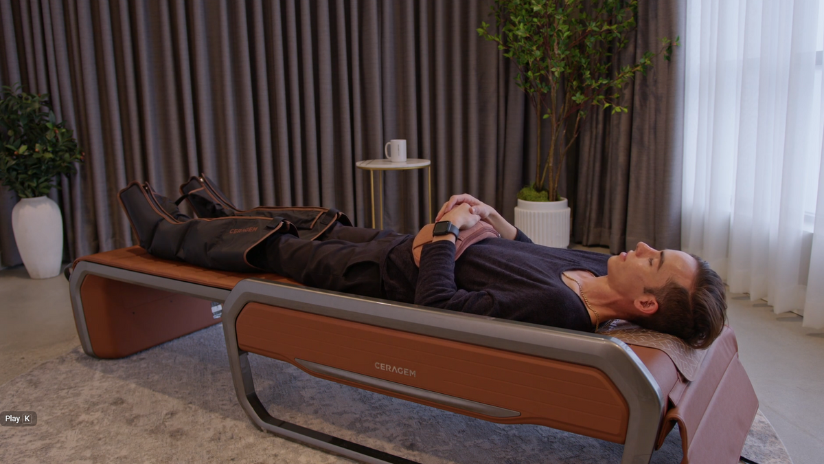 Ceragem Master V9 massage bed in flat bed mode with user receiving full-body spinal therapy in home environment