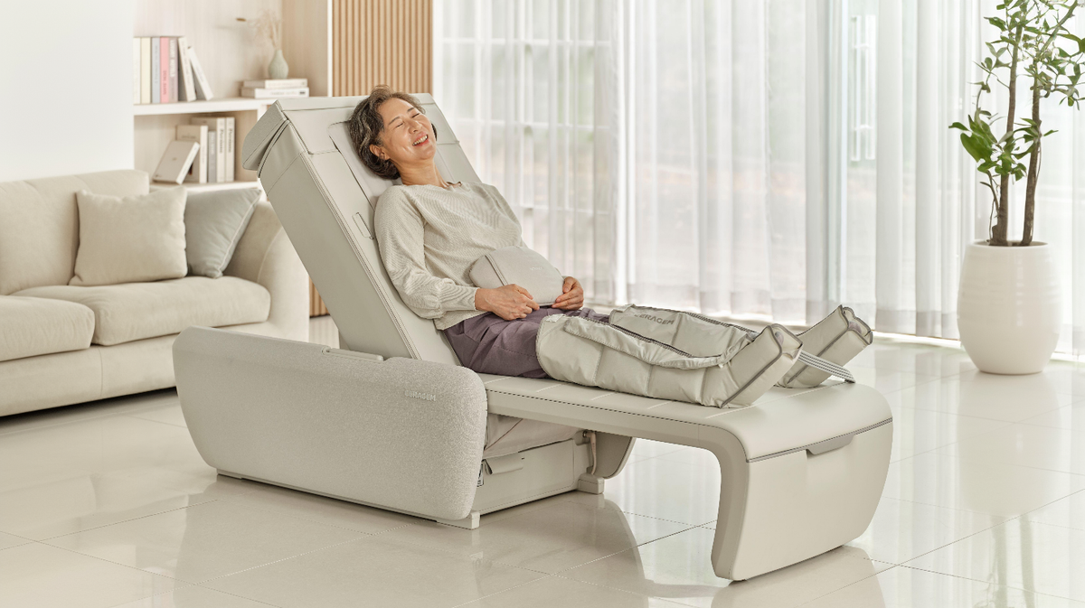 Ceragem Master V9 massage bed in home environment with user receiving leg compression therapy and spinal support