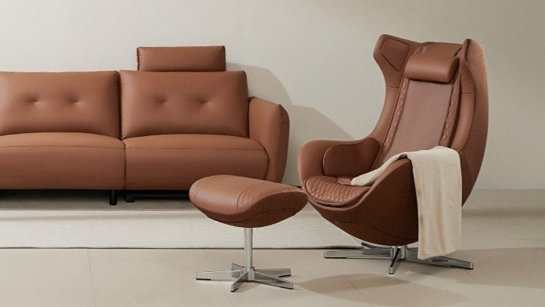 Ceragem Pause M4 massage chair in brown with ottoman placed beside sofa in living room environment