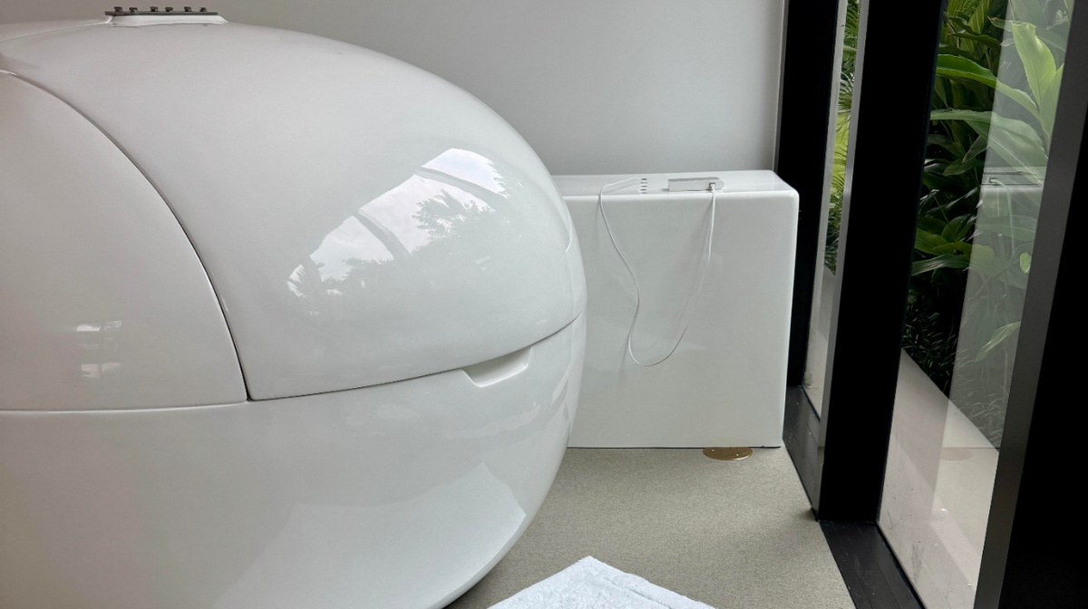 Dreampod home float plus float tank installed in indoor spa bathroom with engine and engine cover displayed.
