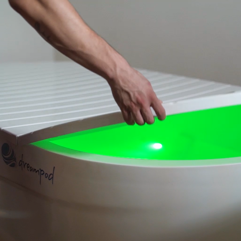 Dreampod Home Float Pro float tank hand adjusting lid with green illuminated water chamber