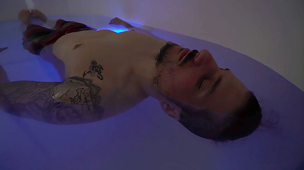 Dreampod Home Float Pro float tank user floating in saltwater during relaxation session with low ambient lighting
