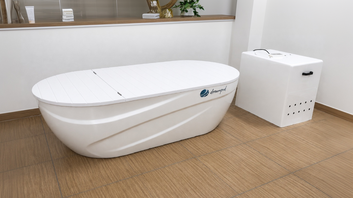 Dreampod Home Float Pro float tank with matching equipment box shown indoors on wood-look flooring for home or commercial float therapy installation context.