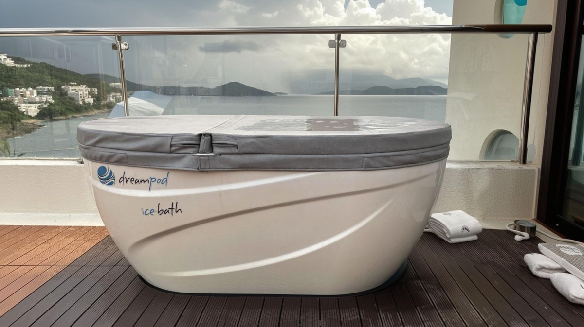 Dreampod ice bath tub with insulated cover on outdoor deck overlooking water in home cold plunge setup