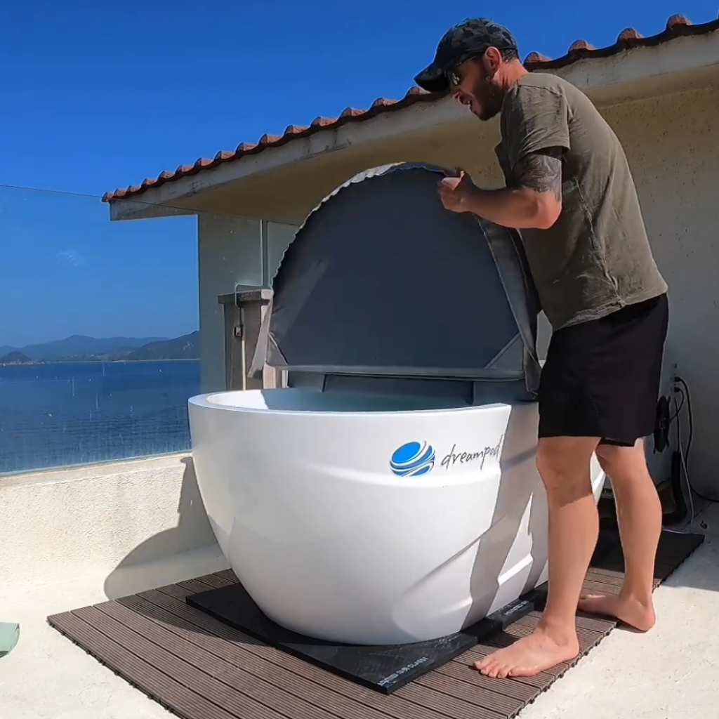 Dreampod ice bath tub being opened outdoors showing insulated cover and cold plunge setup in home environment