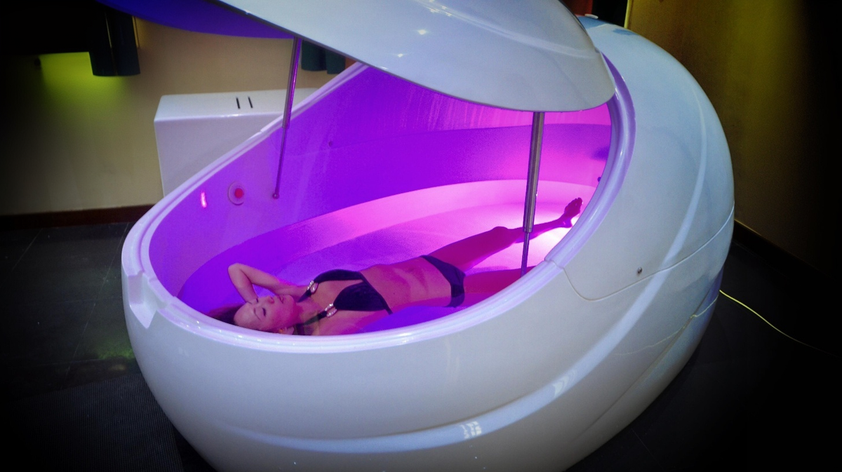 Dreampod V2 float pod commercial float tank with user floating inside illuminated interior environment