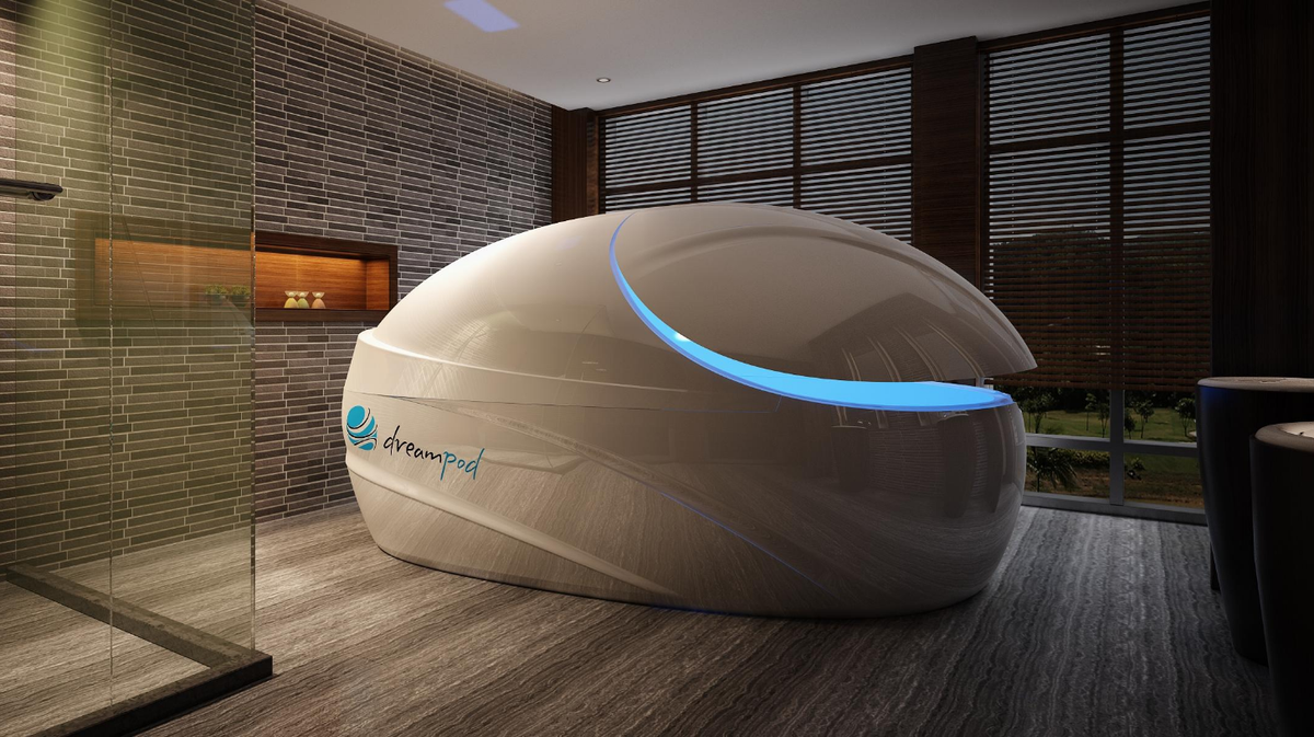 Dreampod Vmax float pod commercial float tank closed in brick wall wellness room with soft ambient lighting
