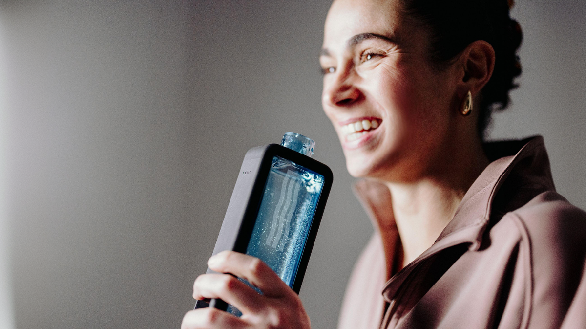 Echo Flask hydrogen water bottle used for drinking in active lifestyle setting with user holding bottle and smiling