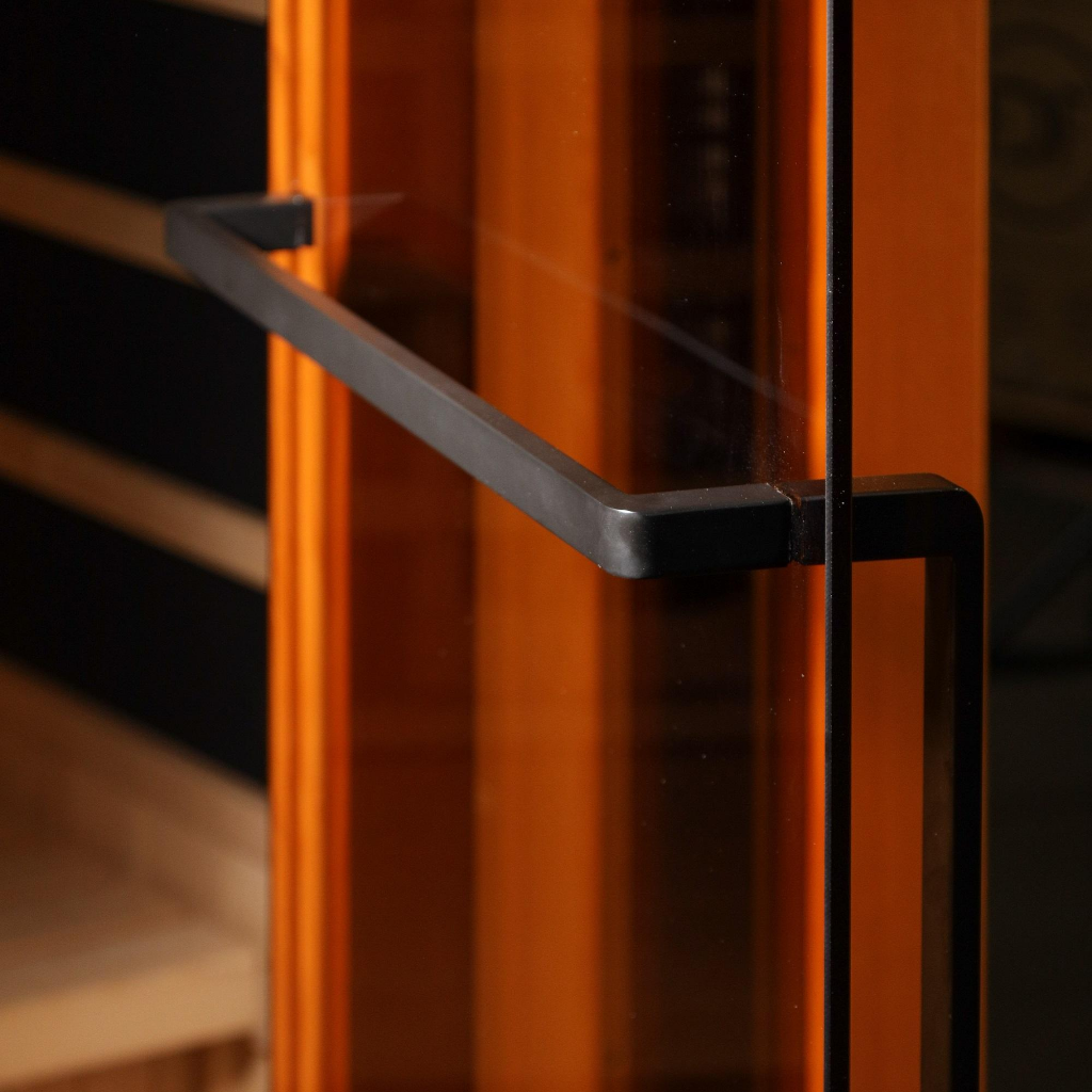 Golden Designs Reserve Edition sauna black finish door handle mounted on bronze tempered glass door with interior heat glow visible through glass panel