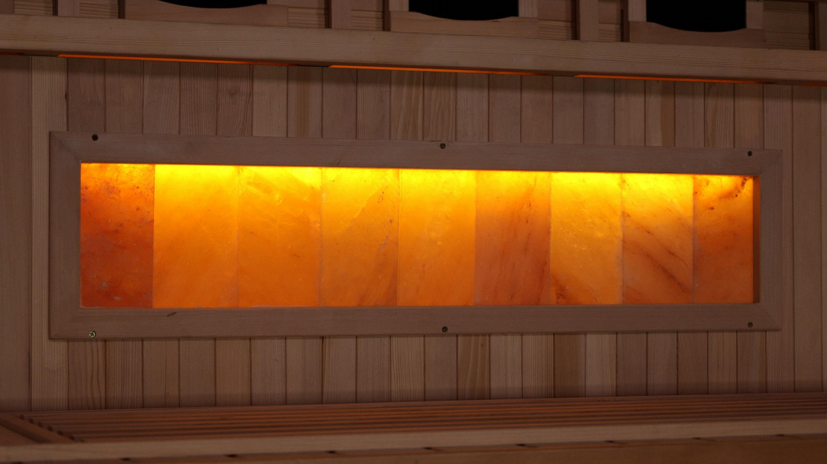 Golden Designs Reserve Edition sauna Himalayan salt bar panel installed beneath bench with backlit salt blocks visible through interior window opening