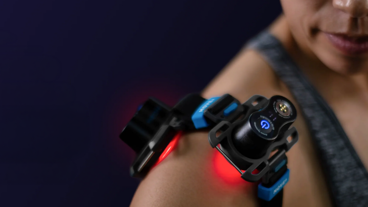 Kineon MOVE+ wearable red light and laser therapy device applied to shoulder joint during indoor use with visible light emission