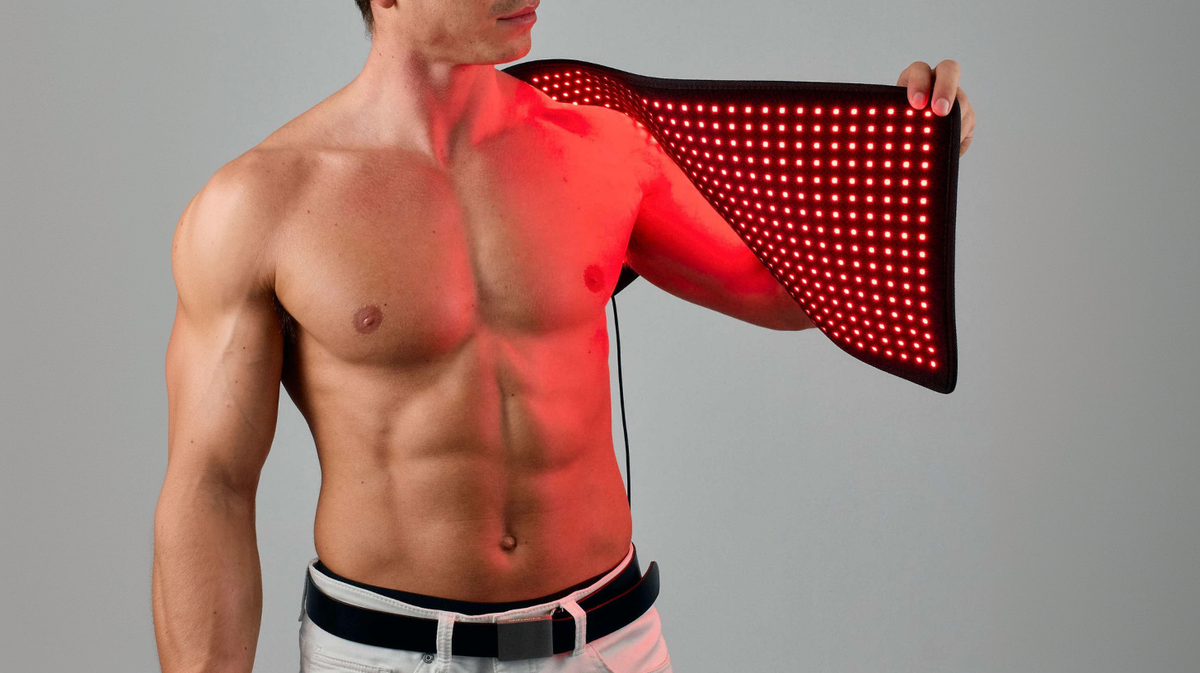 Lumara red light therapy pad applied to shoulder for targeted muscle use in studio environment