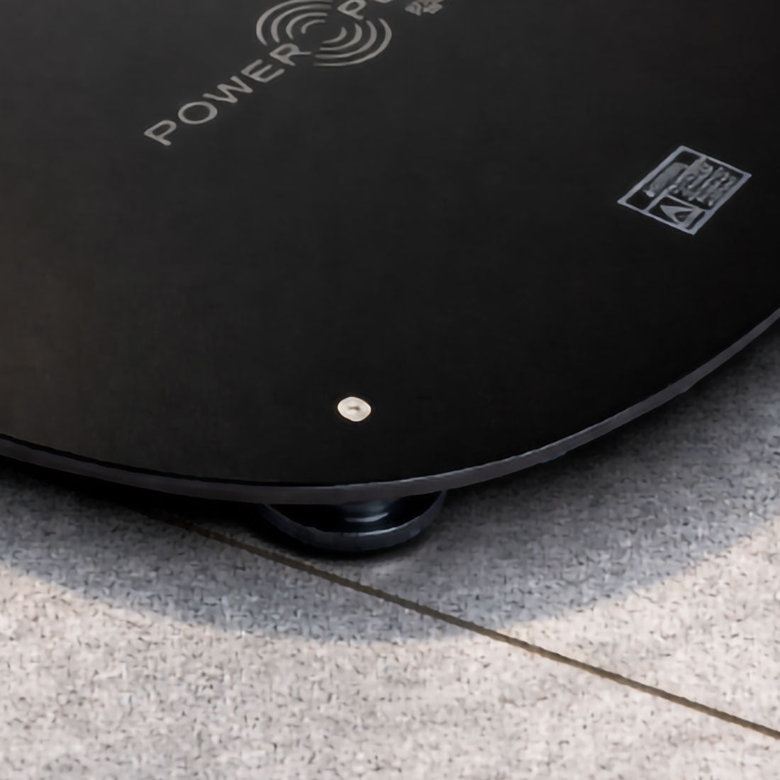 Power Plate MOVE Power Shield vibration dampening platform positioned on tile flooring to help minimize vibration transfer during whole body vibration training; close-up image.