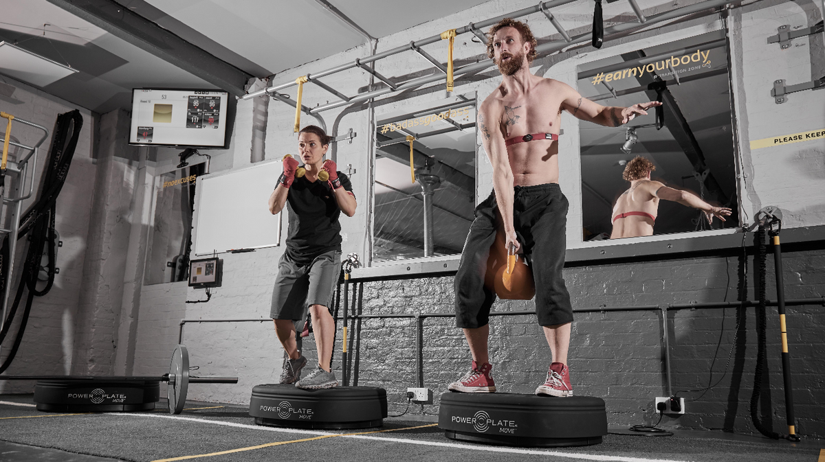 Power Plate MOVE whole body vibration platforms used during kettlebell training session in performance studio environment