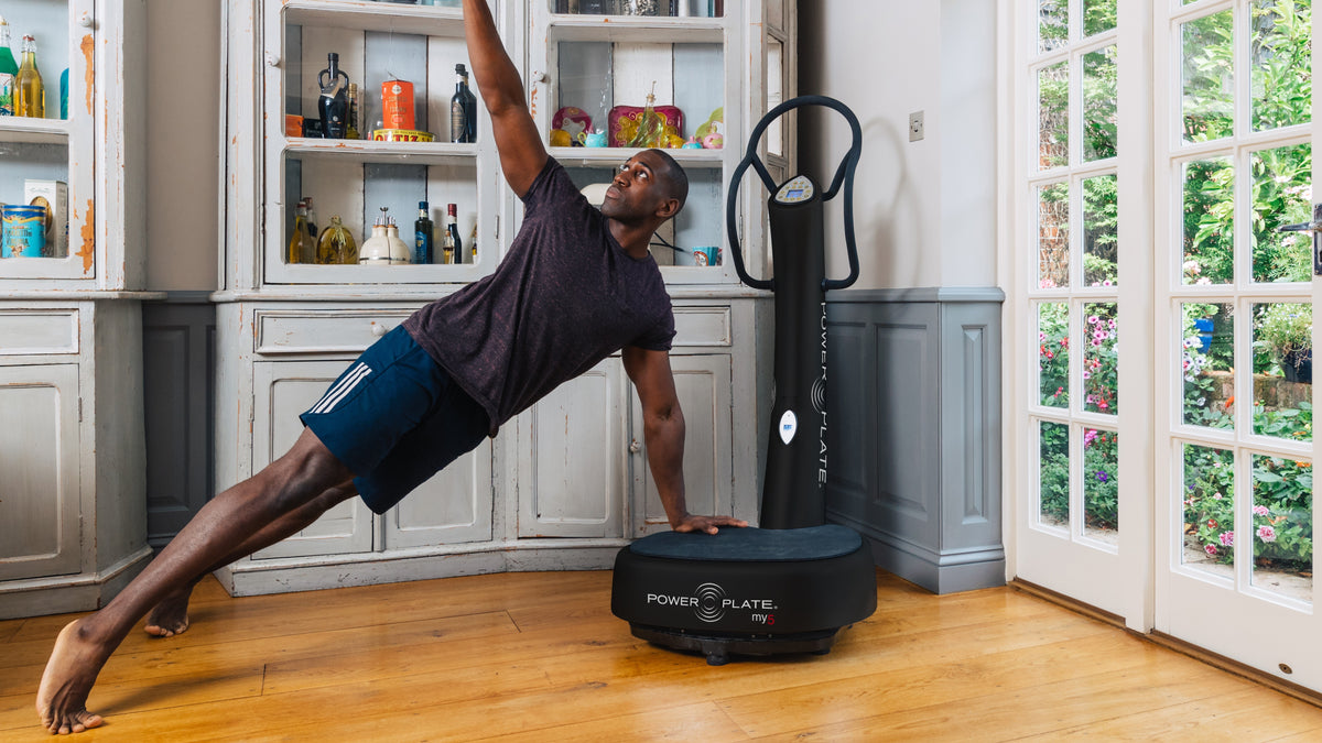 Person performing a side plank exercise using the Power Plate my5 vibration platform at home