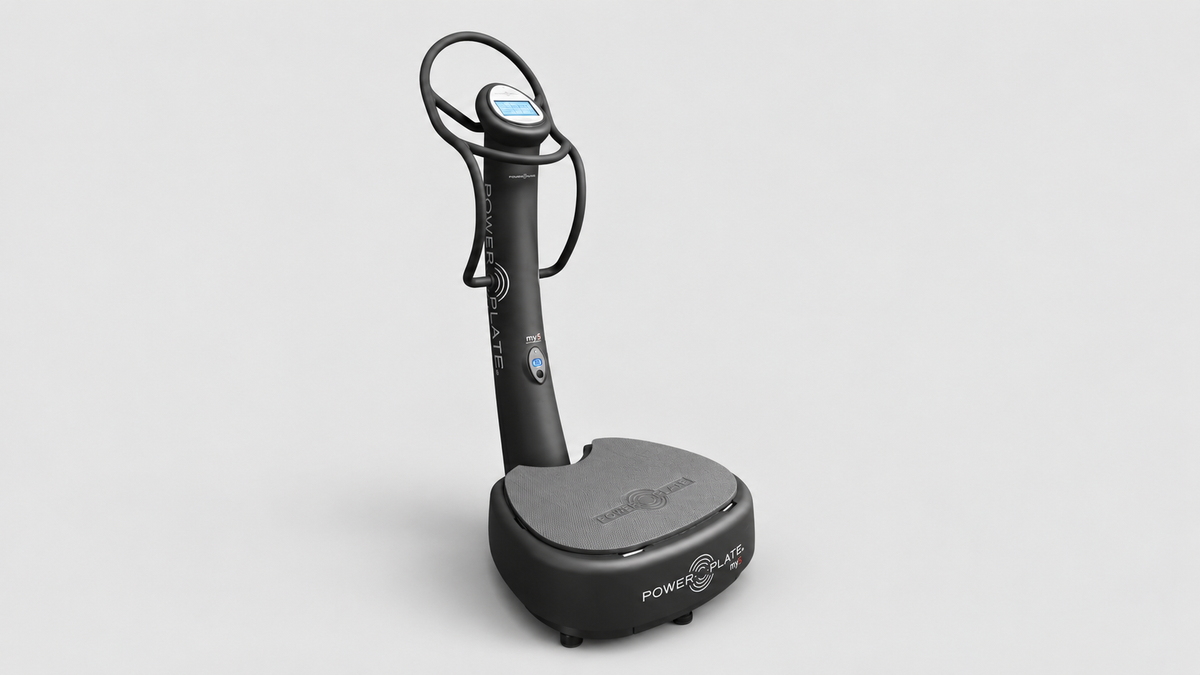 Power Plate my5 whole body vibration system shown at an angled front view on a clean studio background with vibration platform, handrails, and touchscreen console.