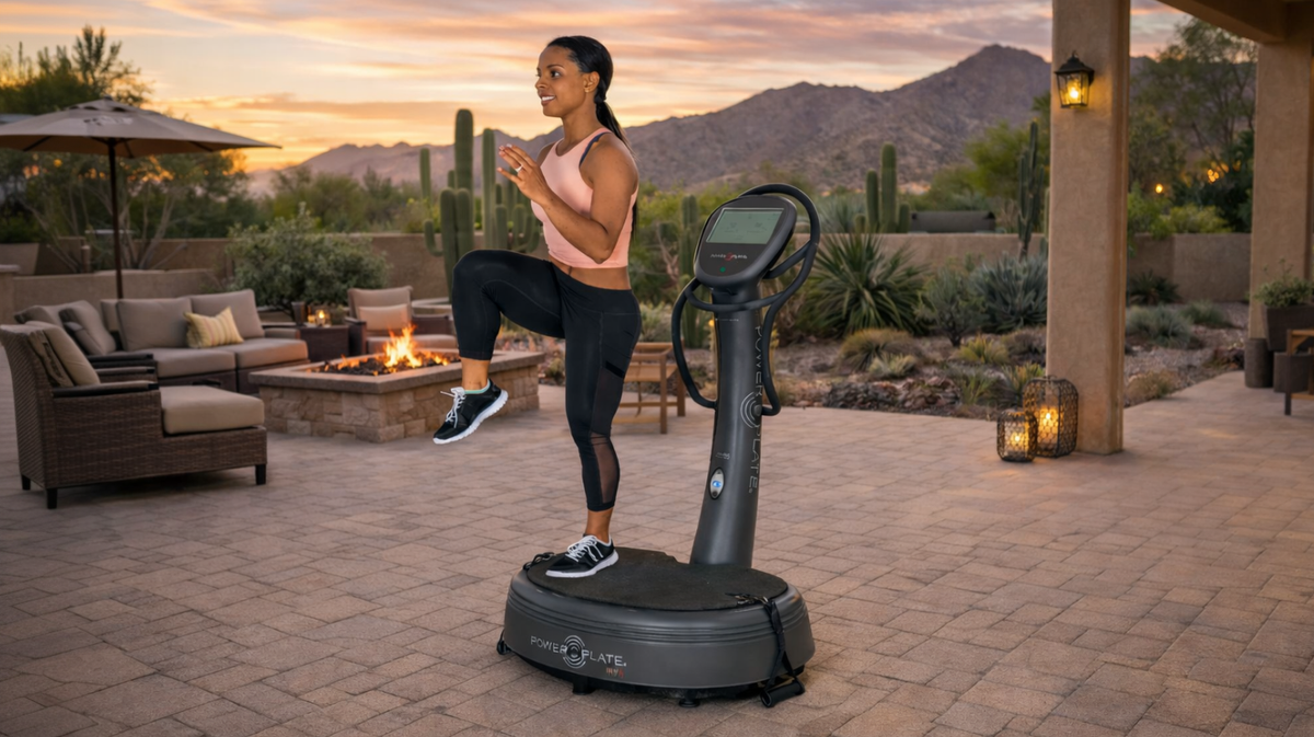Power Plate my8 whole body vibration training platform used for balance and leg exercise on outdoor patio fitness space