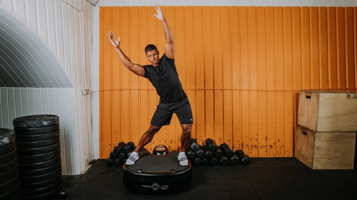Athlete performing balance training on Power Plate pro5 whole body vibration platform in strength training gym