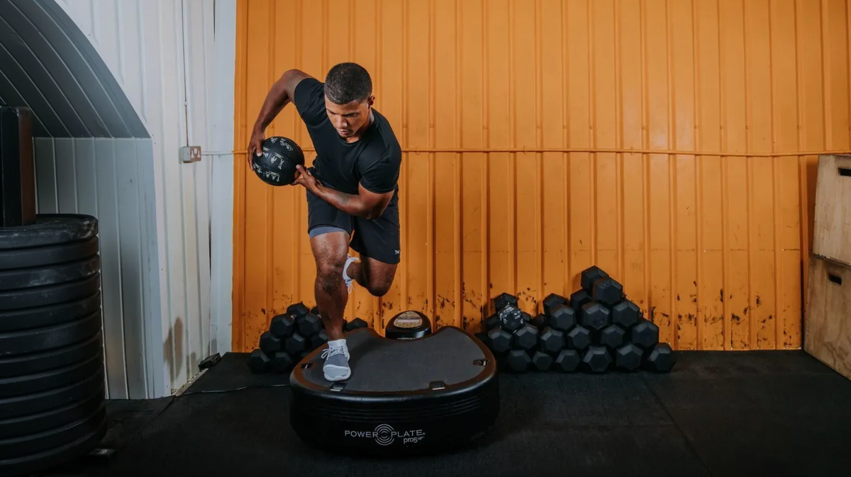 Athlete performing push-up exercise on Power Plate pro5 whole body vibration platform in performance gym
