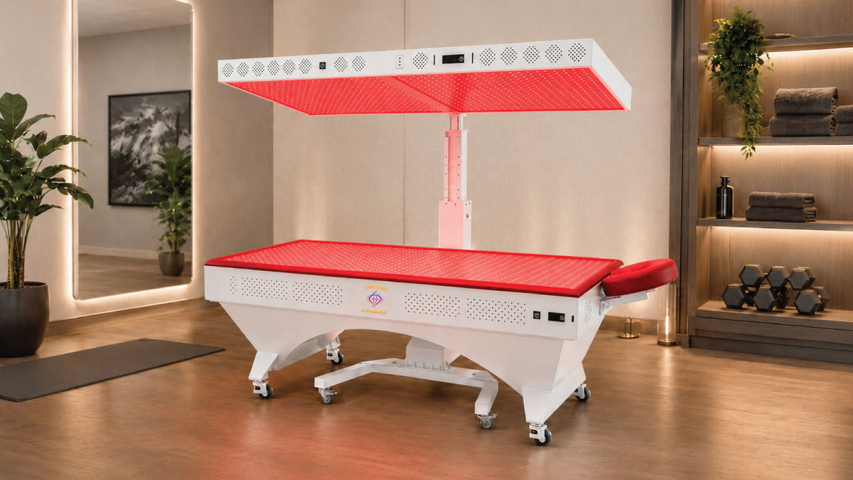 Prestige Pro Modular Red Light Therapy Bed displayed in a professional wellness room with raised upper panel, lower bed panel, warm interior lighting, and full-body red light therapy setup.