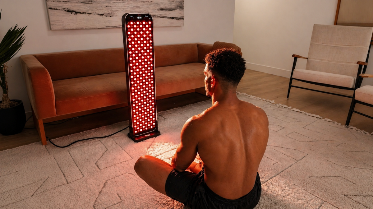Renew Red Light Large Panel red light therapy panel used by male athlete sitting in front of device for post-workout recovery at home