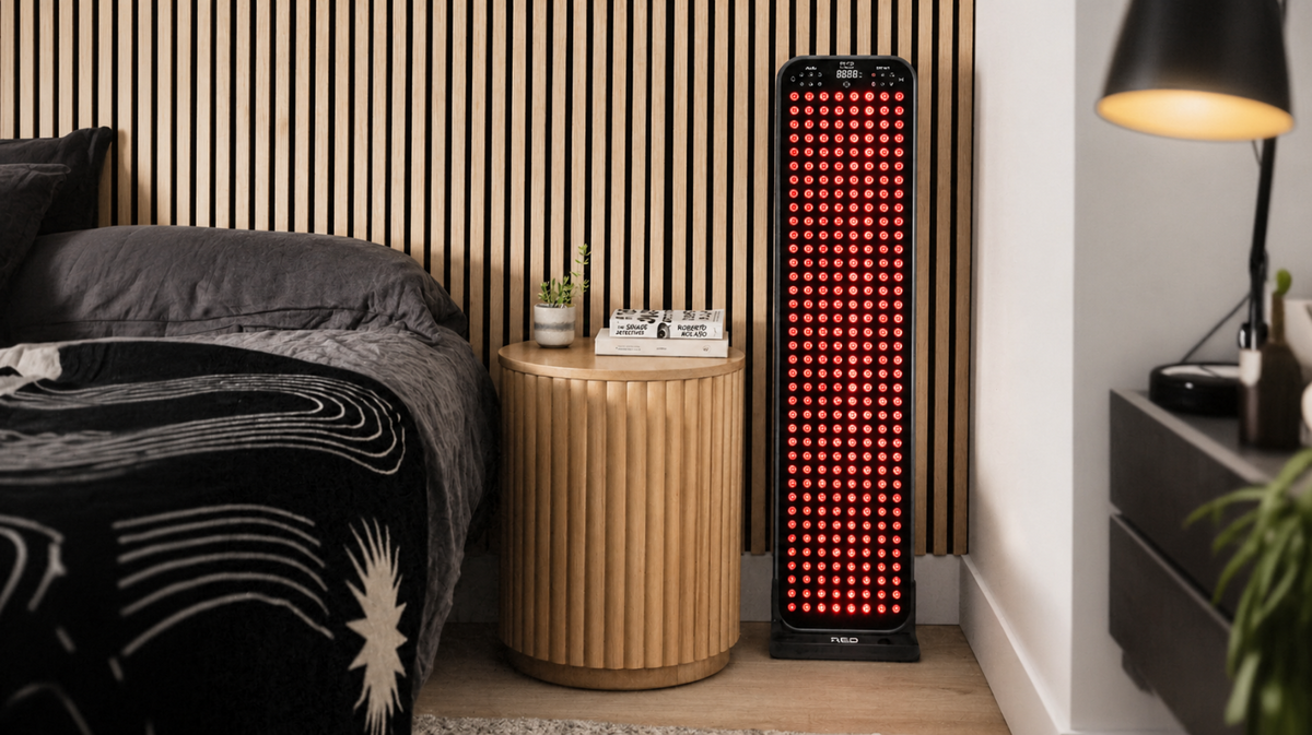 Renew Red Light Large Panel red light therapy panel positioned beside bed in a home bedroom for daily wellness use