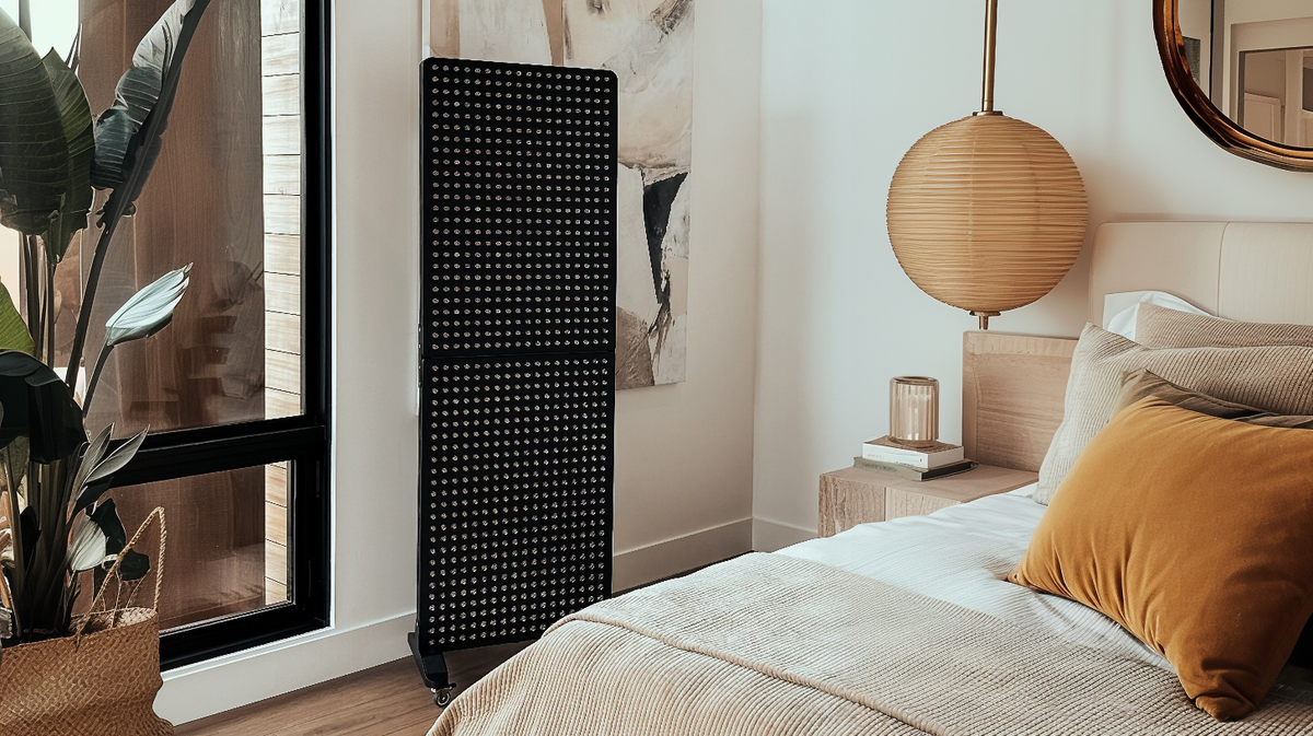 Renew Red Light Max Panel red light therapy panel placed in bedroom wellness setting near bed and window
