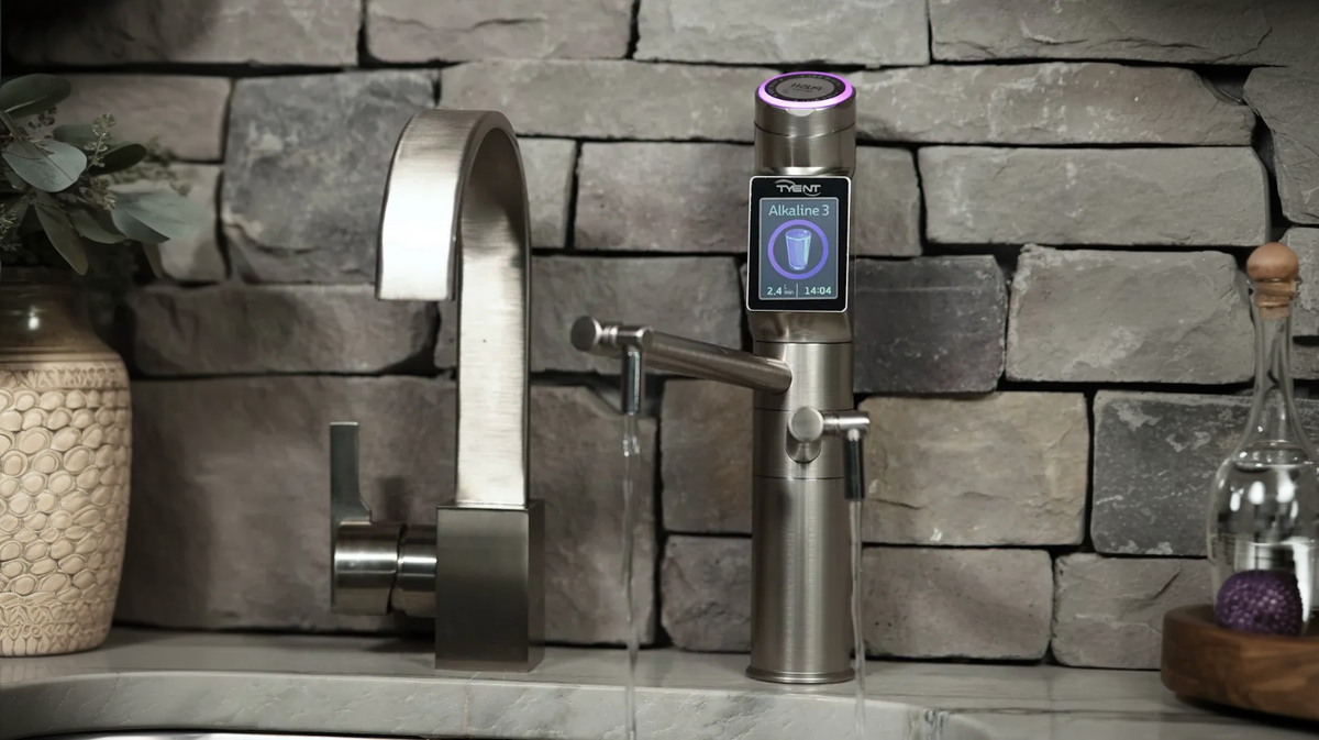 Tyent UCE-13 PLUS ionized water faucet installed at sink with running water and stone backsplash kitchen setting